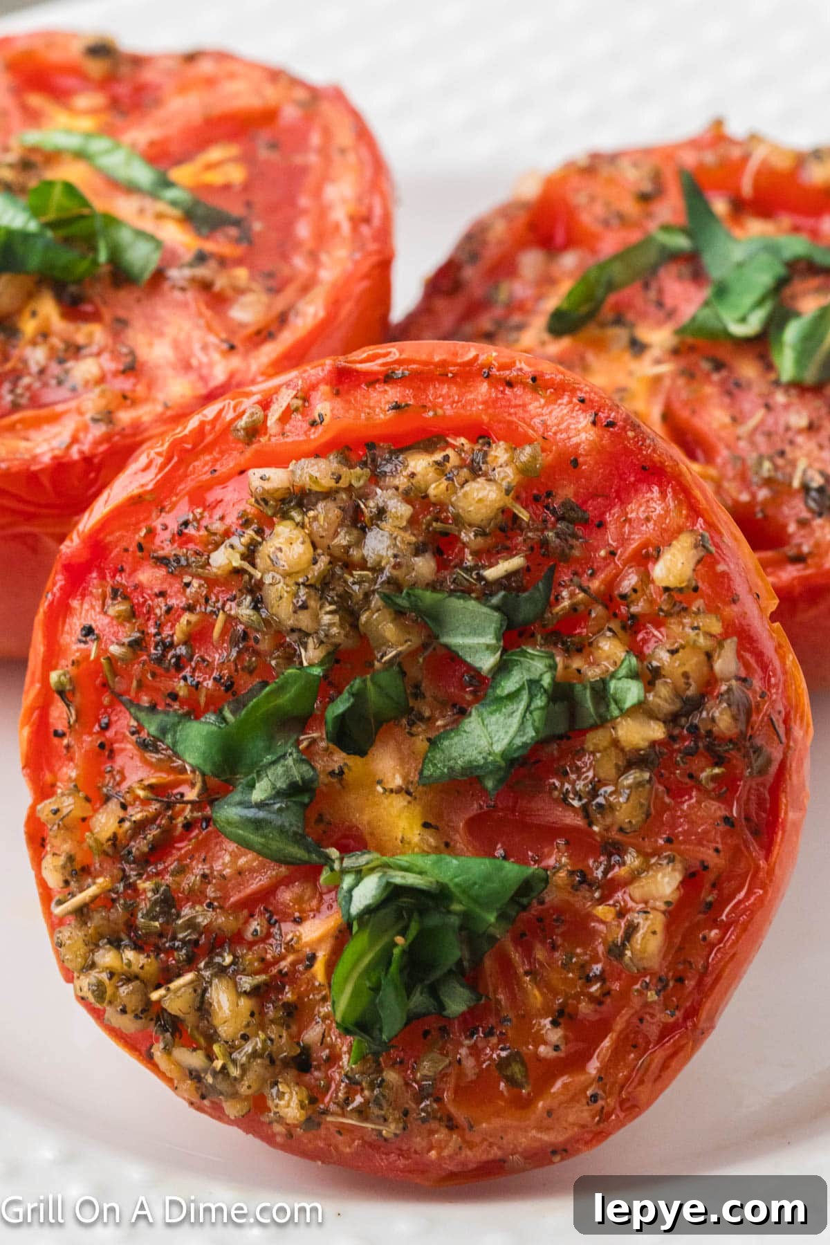 Smoked Tomato Recipe: How to Smoke Tomatoes for Rich Flavor 2 Smoked Tomatoes slices topped with spices and fresh basil