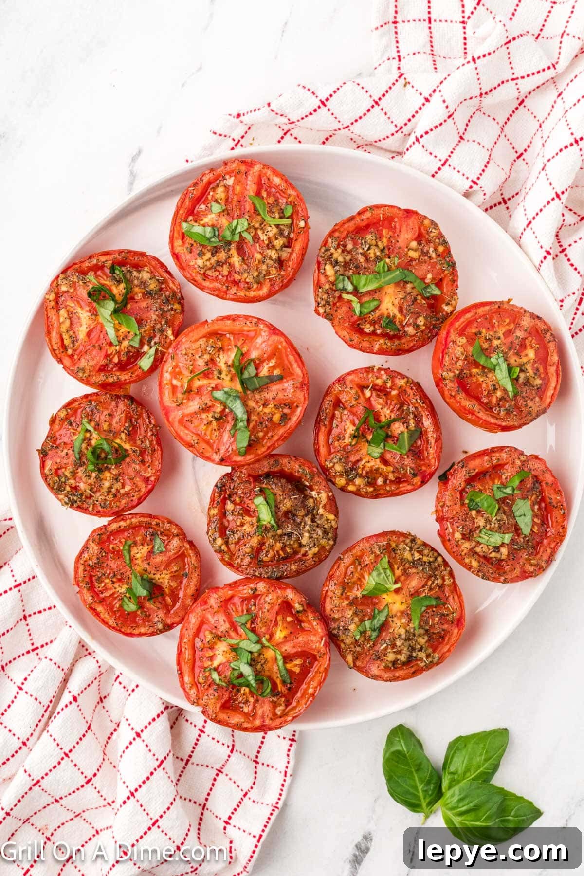 Smoked Tomato Recipe: How to Smoke Tomatoes for Rich Flavor 10 Slice smoked tomatoes on a platter topped with seasoning and fresh basil