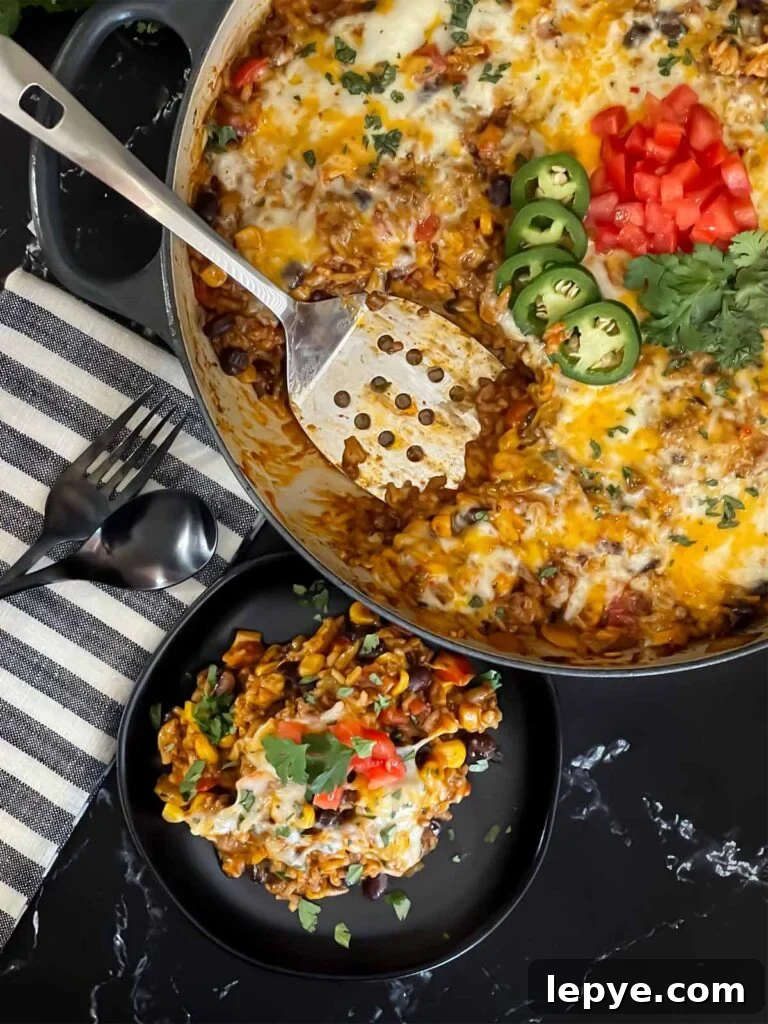 Mexican ground beef with rice with a serving on a dark plate.