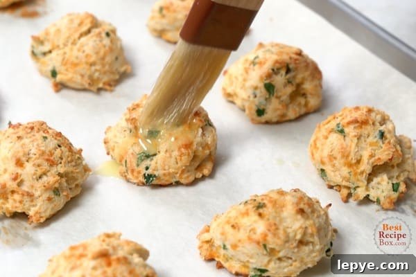 One-Bowl Garlic Cheddar Drop Biscuits Recipe 7 Brushing baked biscuits with butter