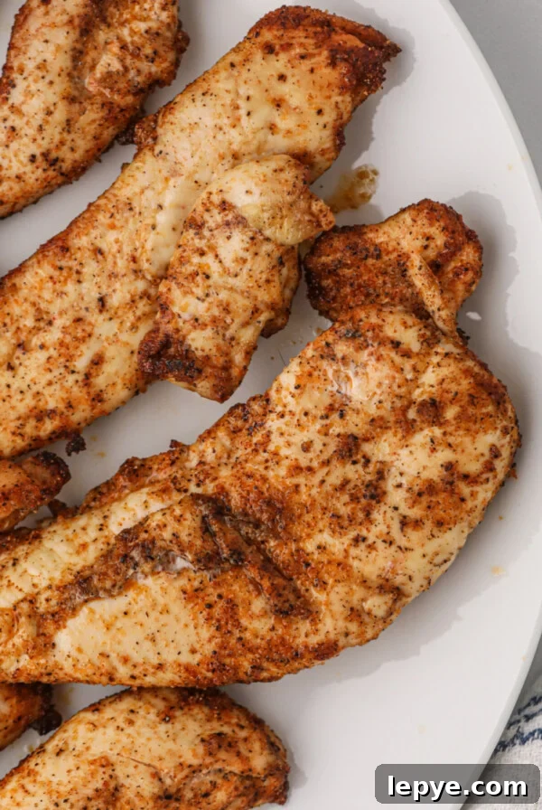 Crispy Bacon-Wrapped Chicken Bites Made in the Air Fryer 10 Air fryer grilled chicken tenders on a white plate.