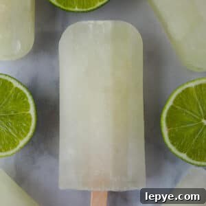Refreshing Lime Popsicle Recipe: Homemade Citrus Ice Pops 11 Lime popsicles surrounded by fresh cut limes.