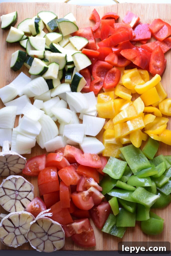 Mediterranean Sheet Pan Roasted Vegetables for Weeknight Meals 6 Diced vegetables on a wooden cutting board.