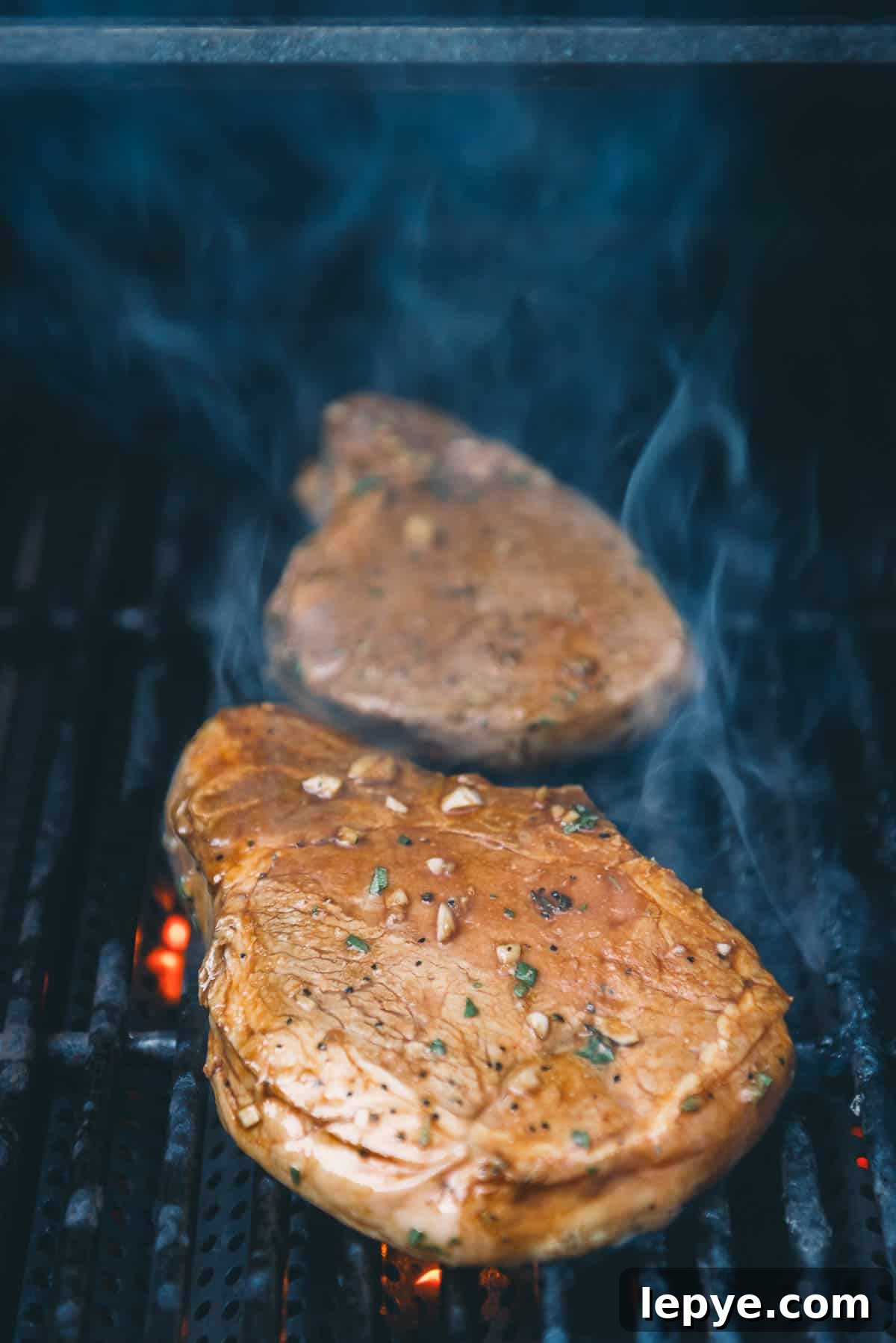 Garlic Herb Pork Chop Marinade for Juicy, Flavorful Chops 6 Pork chops on the grill grates.