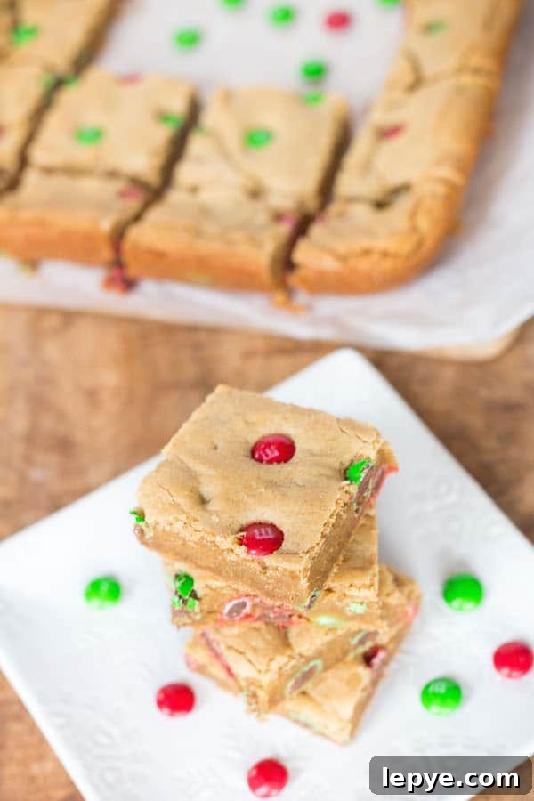 Side view of the Peanut Butter M&M Blondies with even more goodies blurred in the background