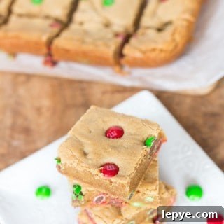 Side view of the Peanut Butter M&M Blondies with even more goodies blurred in the background