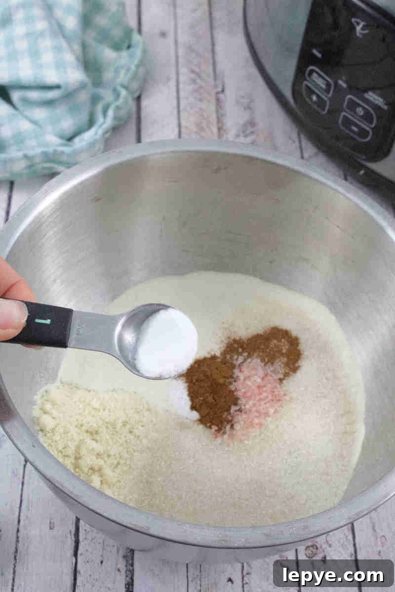 High-Protein Slow Cooker Banana Bread Recipe 5 Baking soda being added to a bowl of flours with a blue linen behind it.