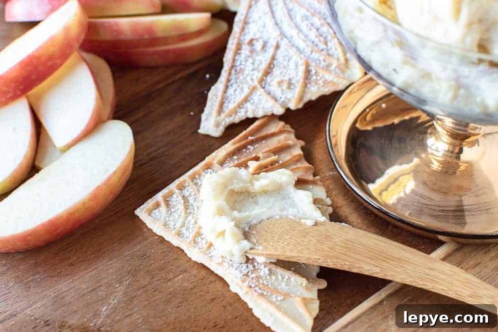 close up of creamy spread on pizzelle with apple slices on the side.
