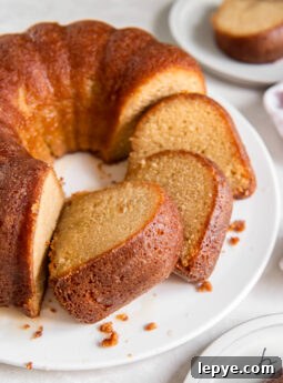 slices of homemade rum cake leaning on each other and bundt cake.