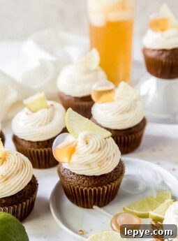 dark and stormy cupcake on a small white plate with lime slices and pipettes