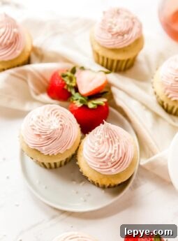 two strawberry moscato cupcakes on white round plate