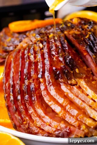 Drizzling glaze over slow cooker brown sugar ham.