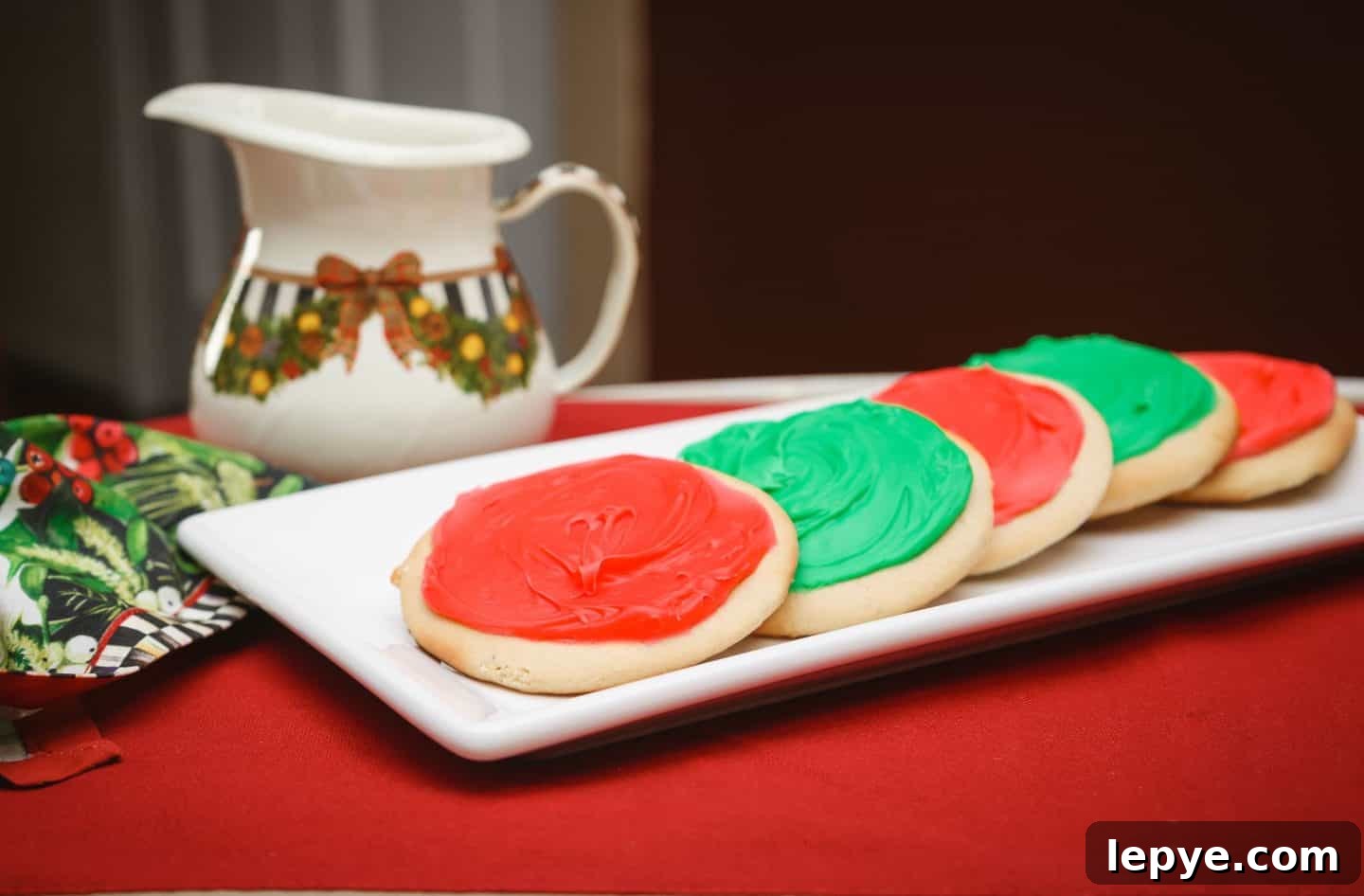 Southern Soul Tea Cake with Sweet Icing - Classic Recipe 3 Why add icing to a traditional tea cake? - Classic Southern tea cakes topped with smooth red and green icing, served on a white platter with Christmas décor. A modern twist on Black folks’ tea cakes. Soulful holiday dessert by The Soul Food Pot®.