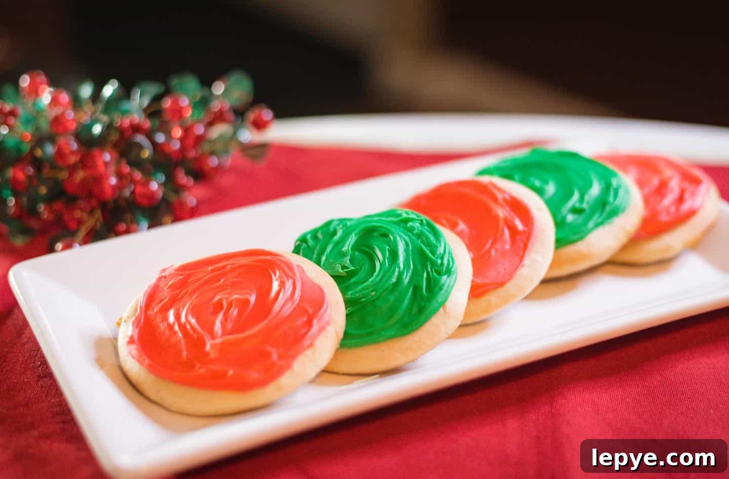 Southern Soul Tea Cake with Sweet Icing - Classic Recipe 6 Shaunda's Soul Food Sense - texture, appearance, and tips for iced tea cakes - A holiday tray of iced Southern tea cakes, frosted in Christmas colors and set against red linens with seasonal decorations. Step-by-step homemade dessert from The Soul Food Pot®, honoring Black culinary heritage.