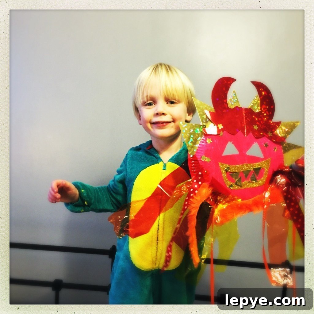 Chinese Dragon Mask Craft for Kids: Step-by-Step Paper Mask Tutorial 2 toddler holding up a dragon mask craft they've made