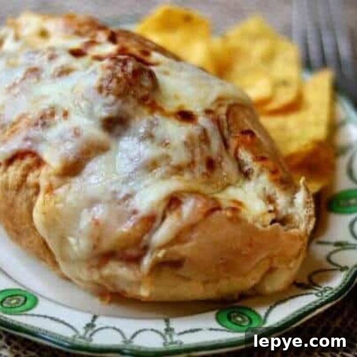 Meatball sandwich covered in melted Mozzarella cheese.