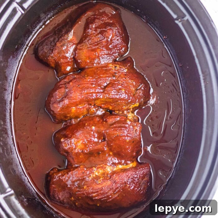 Overhead view of the finished meat in a slow cooker.