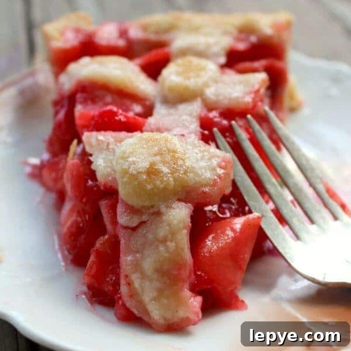 Close up of a slice of apple pie made with red hots candy.