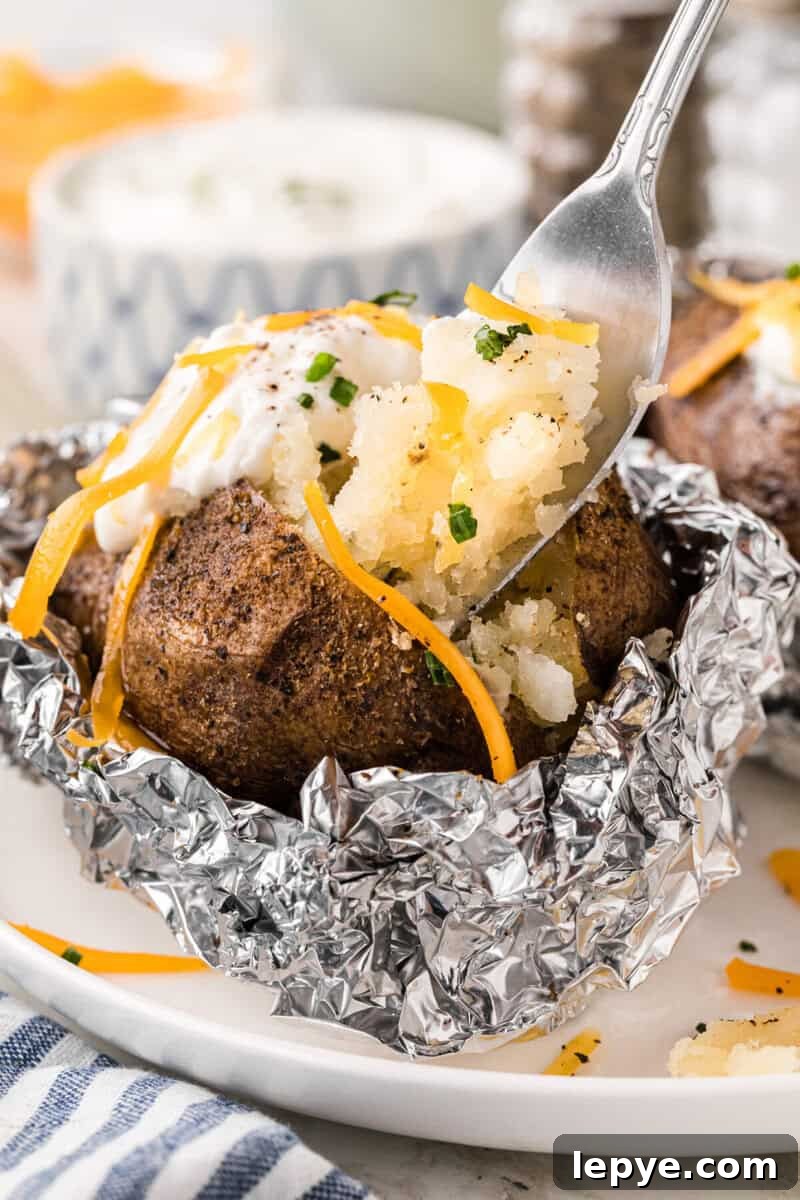 Perfect Slow Cooker Baked Potatoes: Creamy, Hands-Off Recipe 12 using a fork to eat the baked potato.