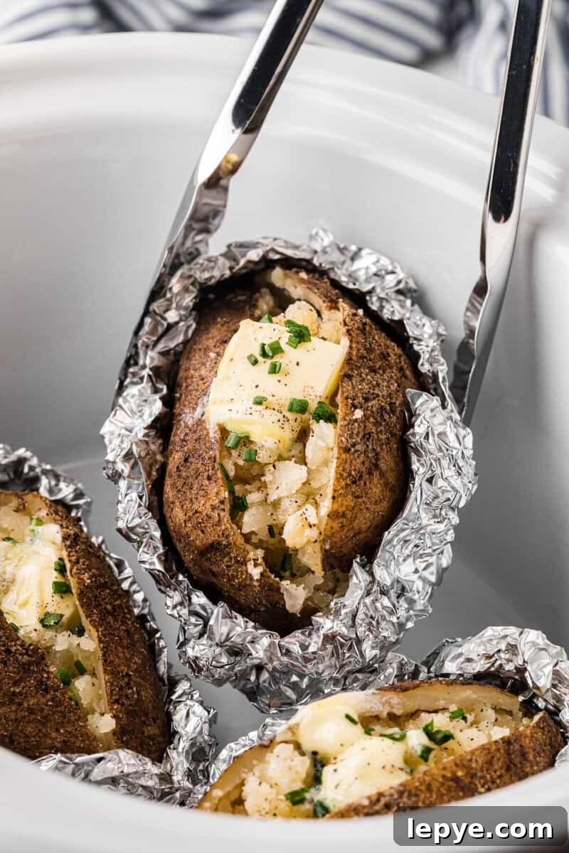 Perfect Slow Cooker Baked Potatoes: Creamy, Hands-Off Recipe 8 using tongs to serve the baked potatoes.