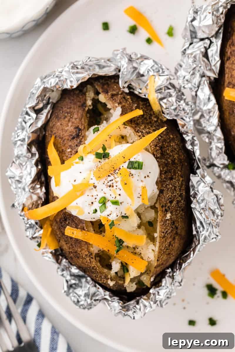 Perfect Slow Cooker Baked Potatoes: Creamy, Hands-Off Recipe 10 closeup of a baked potato on a white plate.