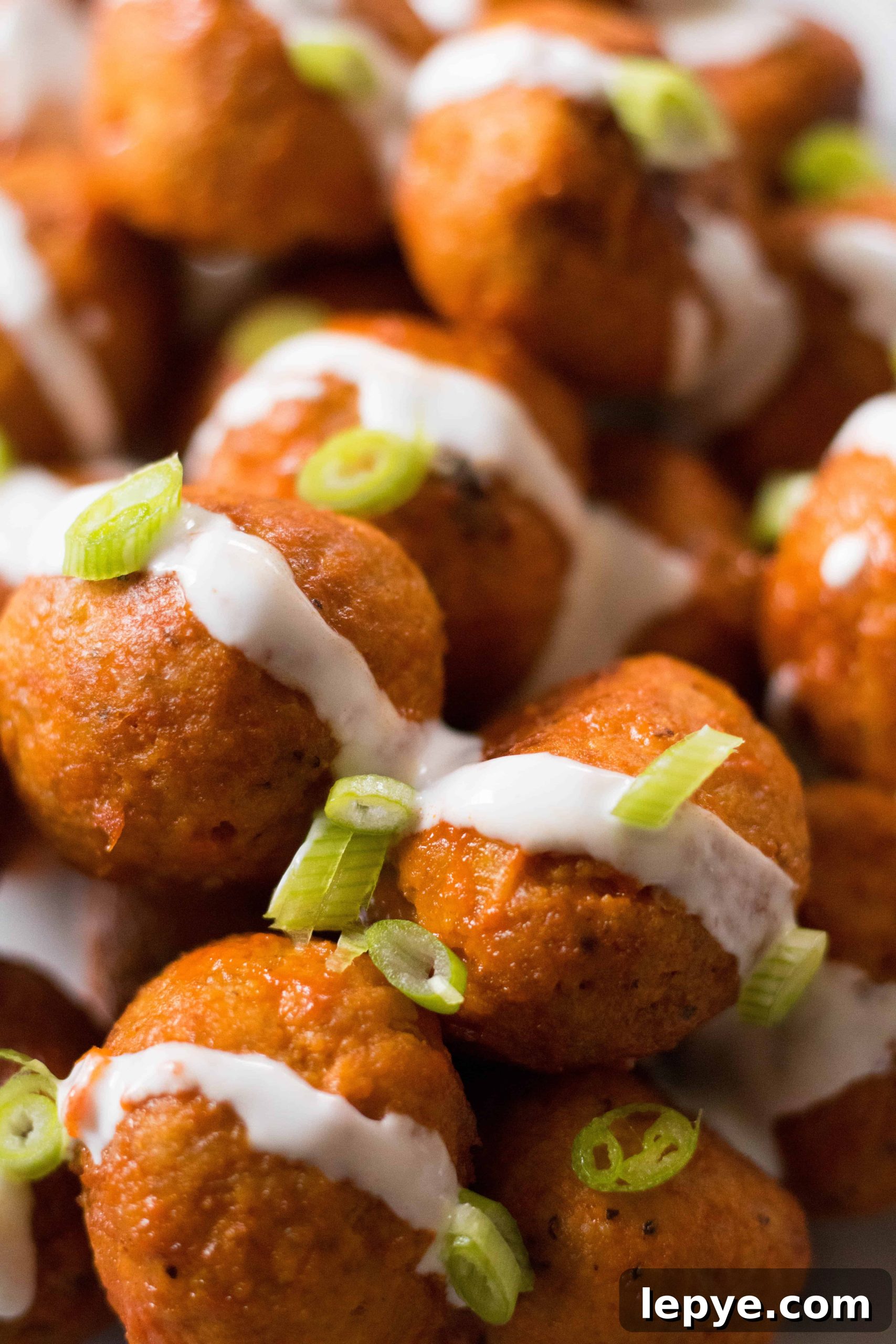 Chicken buffalo meat balls with ranch and onions on top