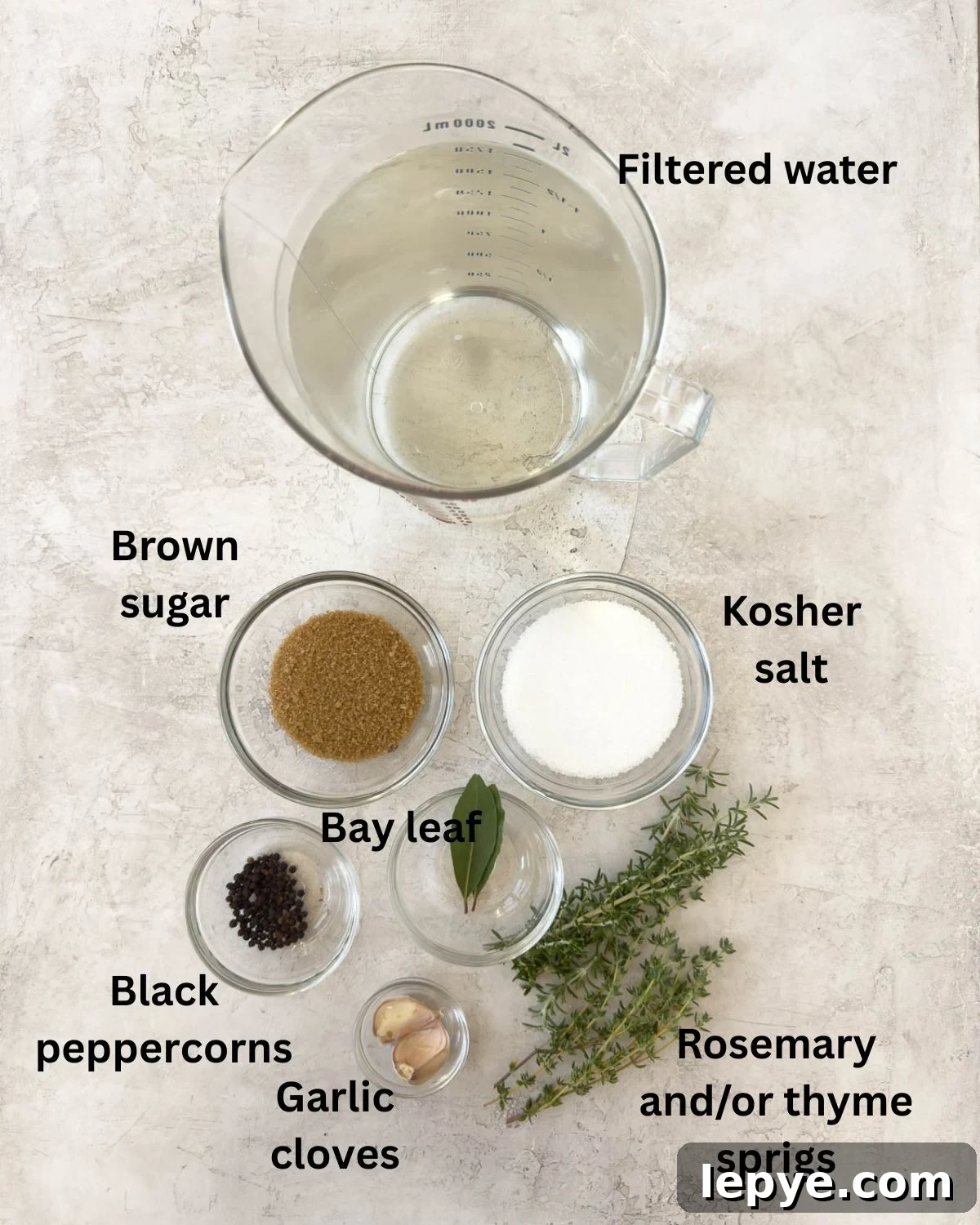 Ingredients for pork brine in glass prep bowls on the counter.