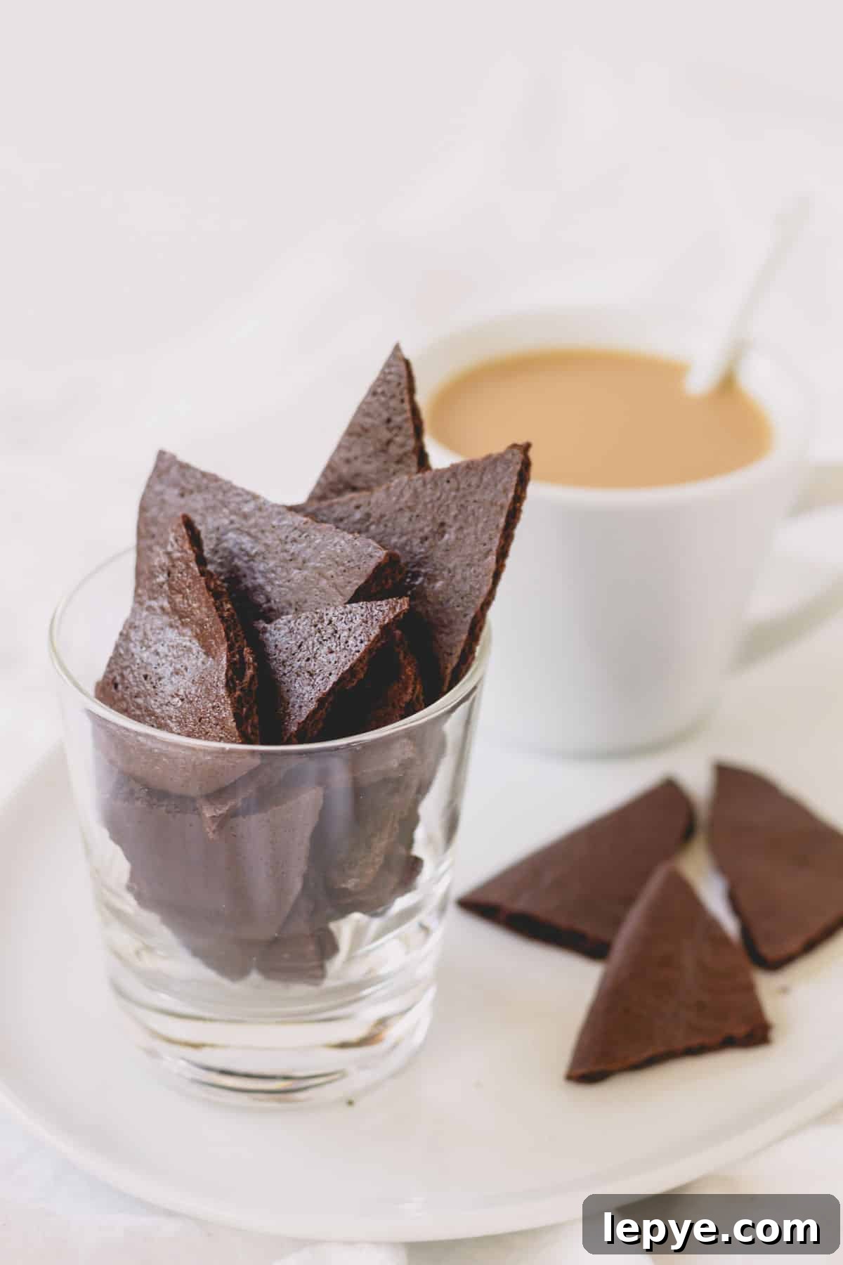 Crunchy Brownie Crisps: Chocolate Bites Recipe 3 A platter with a cappuccino, a glass of brownie crisps, and a few crisps on the tray.