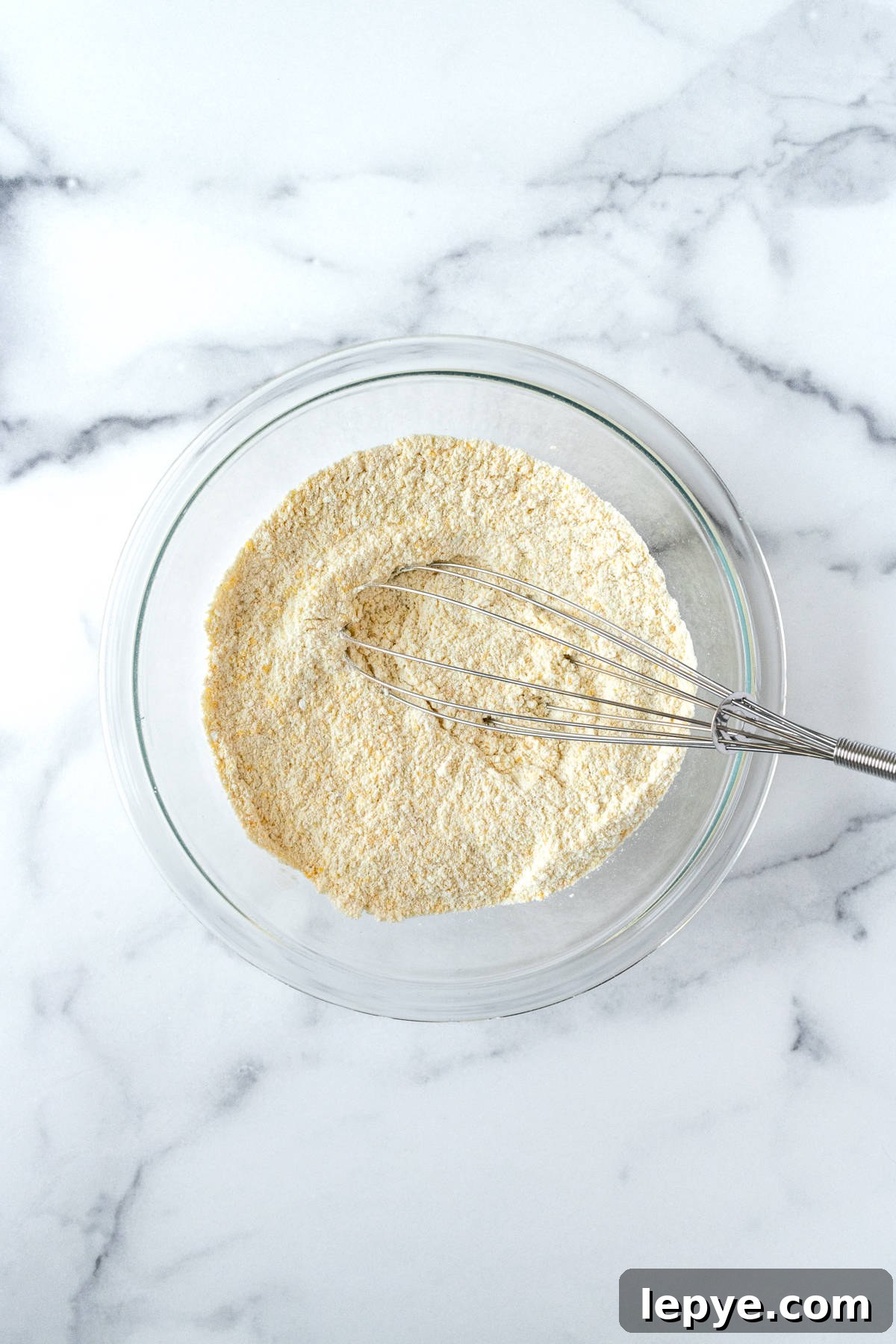 Honey-Glazed Cornbread Recipe with Golden Crust and Sweet Drizzle 4 Cornbread Dry Ingredients with a whisk in a glass mixing bowl.