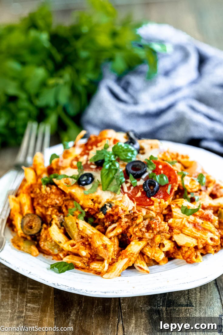 Our deliciously hearty pizza casserole will be kids of all ages will race to the dinner table when this is on the menu! Ooey-gooey, cheese YUM! pizza casserole on a plate
