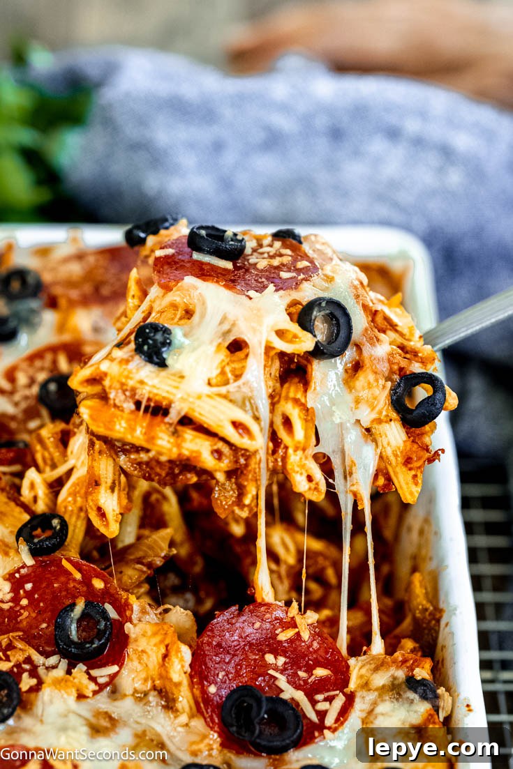 Our deliciously hearty pizza casserole will be kids of all ages will race to the dinner table when this is on the menu! Ooey-gooey, cheese YUM! scooping pizza pasta casserole