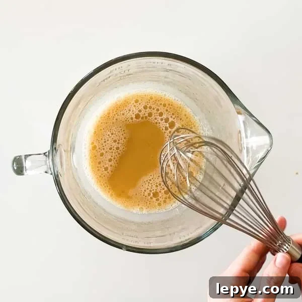 Gluten-Free Peach Cobbler with Almond Butter Caramel Sauce 11 Mixing the wet batter ingredients in a glass mixing bowl with a whisk.