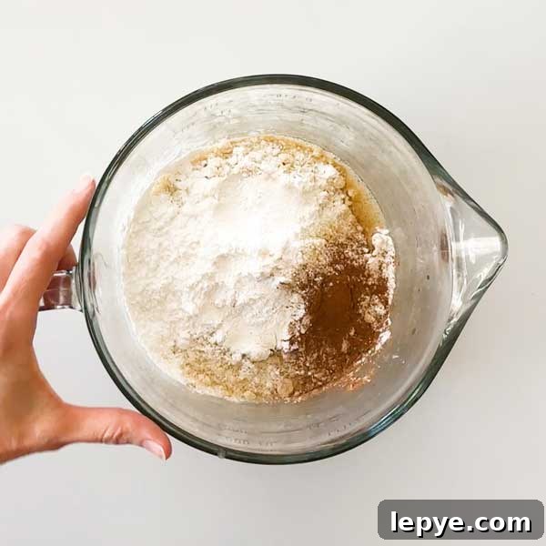 Gluten-Free Peach Cobbler with Almond Butter Caramel Sauce 12 Adding the dry ingredients to the glass mixing bowl.