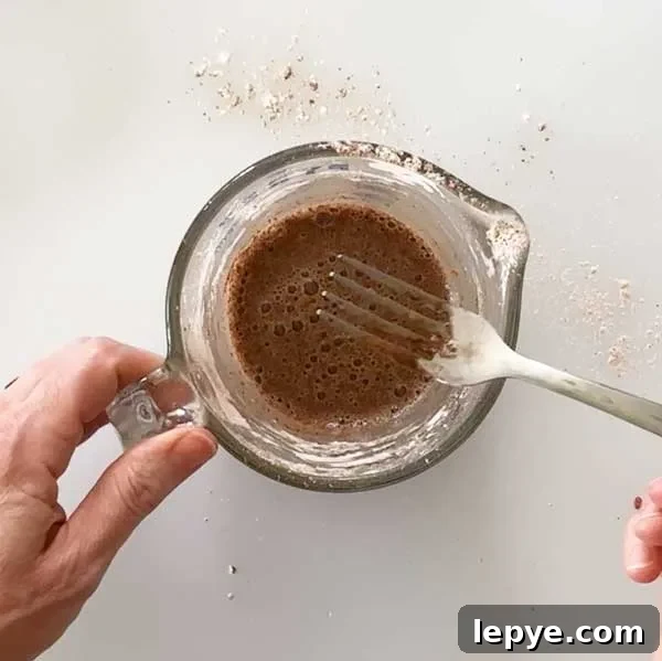 Gluten-Free Peach Cobbler with Almond Butter Caramel Sauce 8 Mixing wet ingredients to pour over the peaches in a measuring glass with a fork.