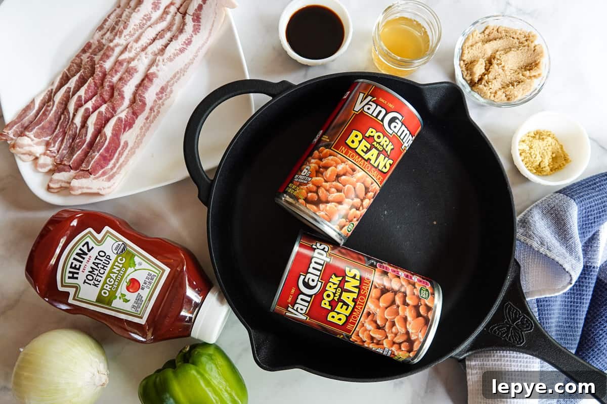 Smoked Baked Beans with Bacon — Flavorful BBQ Side Dish 3 canned beans inside cast iron pan with bacon and other ingredients around