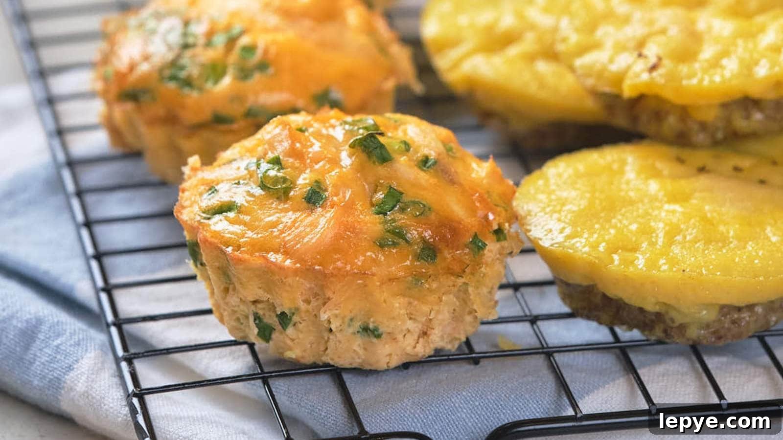 15 High-Protein Breakfasts to Power Your Morning Hustle 6 Golden, cheesy muffins with herbs cool on a wire rack, ready to be served.