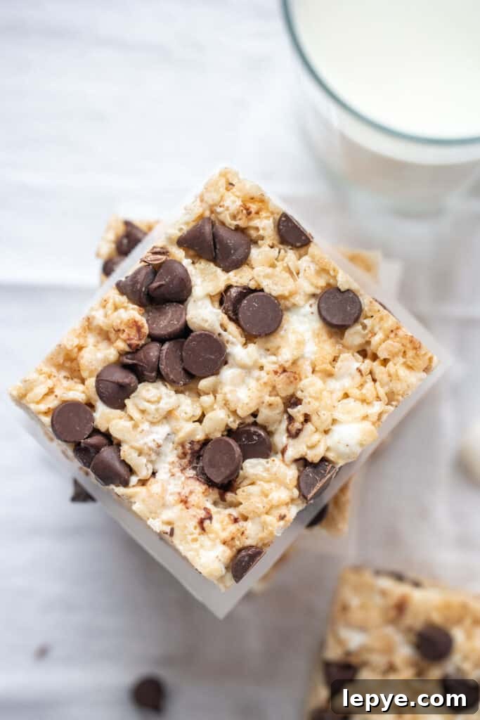 A stack of Chocolate Chip Rice Krispie treats and a glass of milk