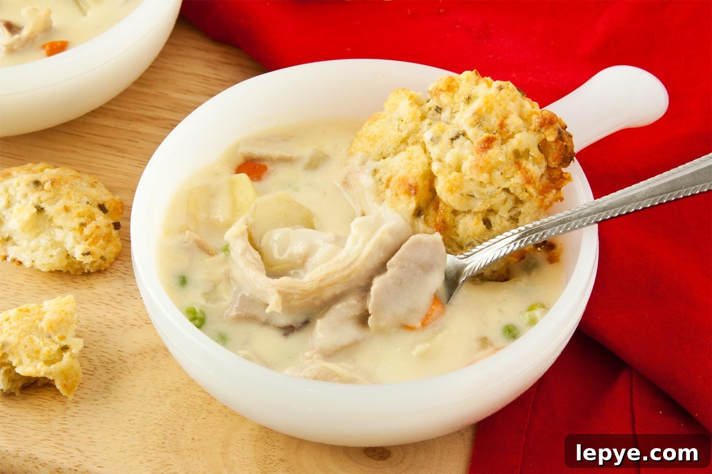 Close up of creamy chicken pot pie soup with spoon