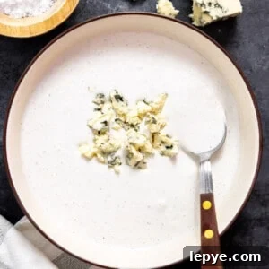 Creamy Blue Cheese Dressing Recipe for Salads and Wings 6 Blue cheese dressing in a bowl topped with crumbled cheese.
