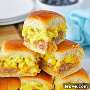 Sausage egg and cheese breakfast sliders stacked and pulled apart on Hawaiian rolls.