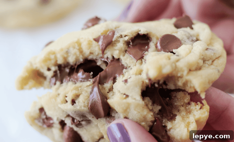hand breaking chocolate chip cookie in half