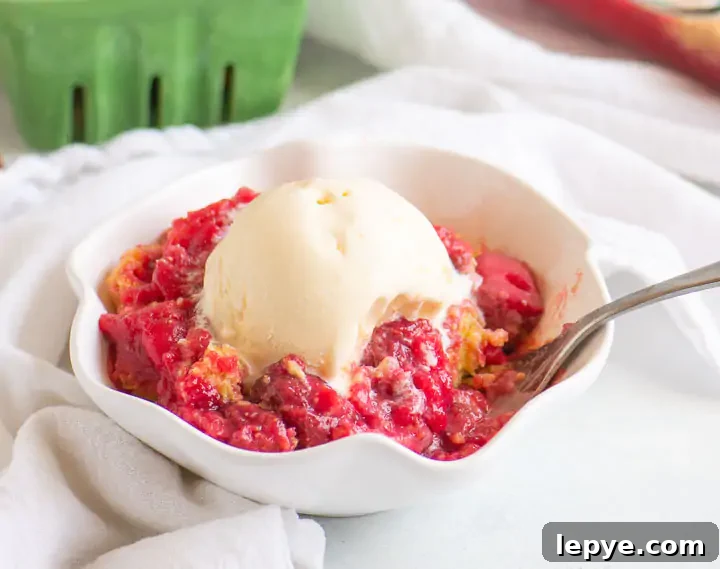 fork digging into a bowl of cobbler with vanilla ice cream